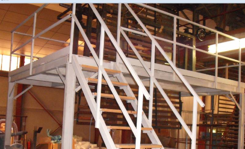 Pose d'une rambarde et de garde-corps en métal d'escalier dans un bâtiment industriel à Meyzi